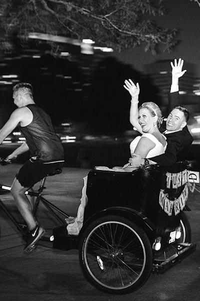 side view of bride and groom riding in a pedicab
