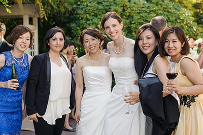 brides posing with guests at wedding reception